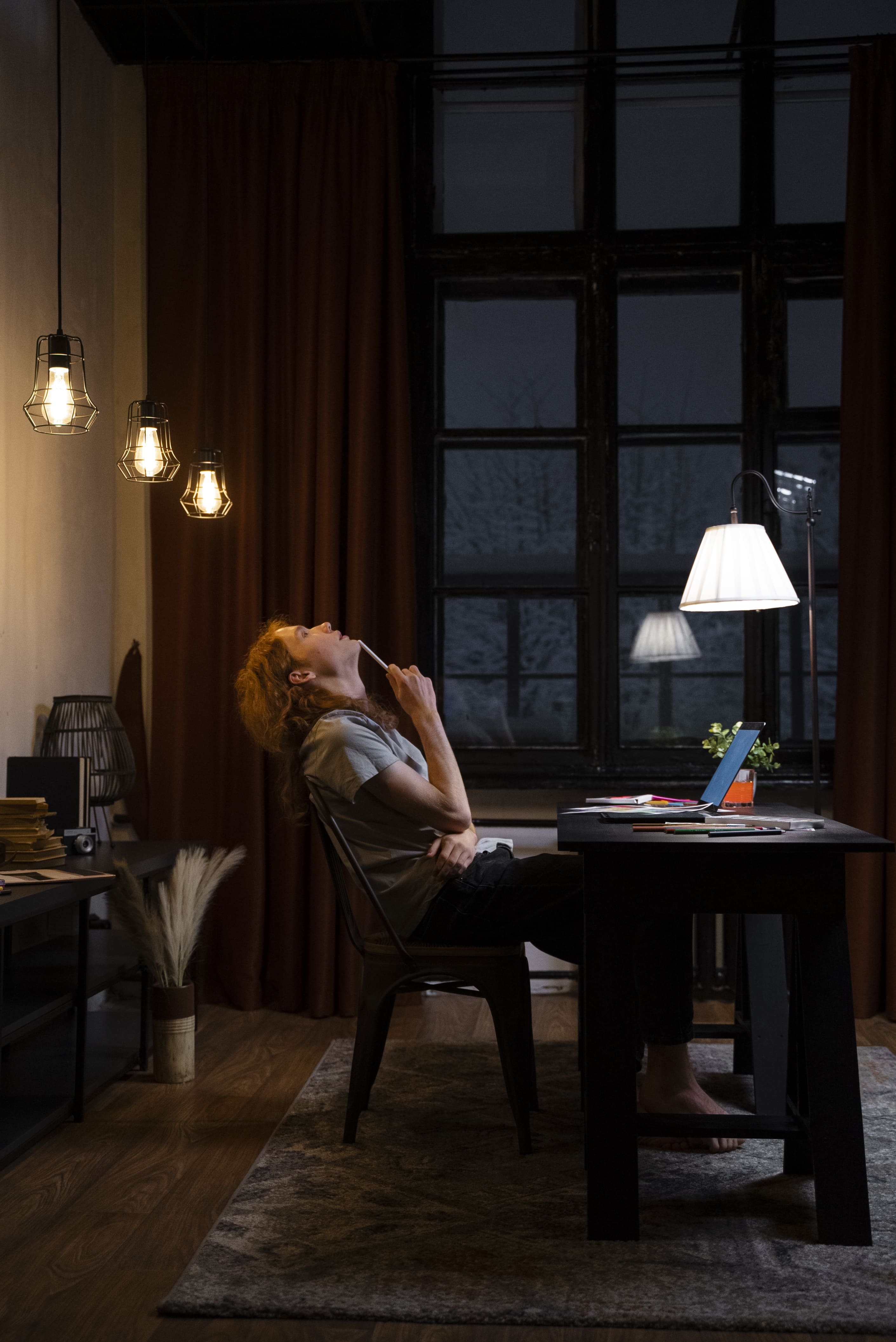 Full shot of a woman sitting at a desk, highlighting a modern office setup.
